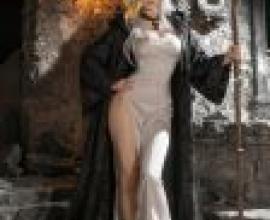 witch，A woman with long blonde hair wearing a white dress and a black cape.