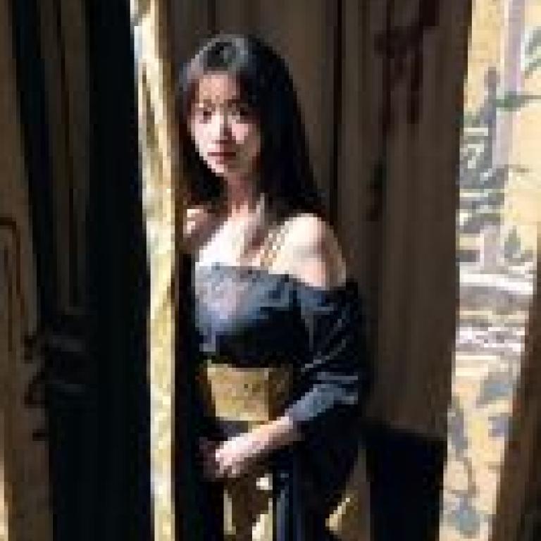 Kyokofukada：一位身穿黑衣的女子站在窗簾前。