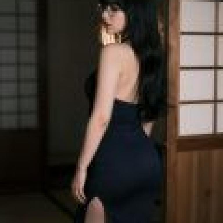 The Japanese Phantom of an Old House，A woman wearing blue and posing in front of a wood wall.