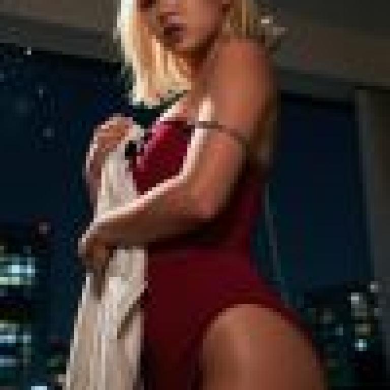 Ancient sexiness，A blonde woman is wearing a red dress and holding a white towel.