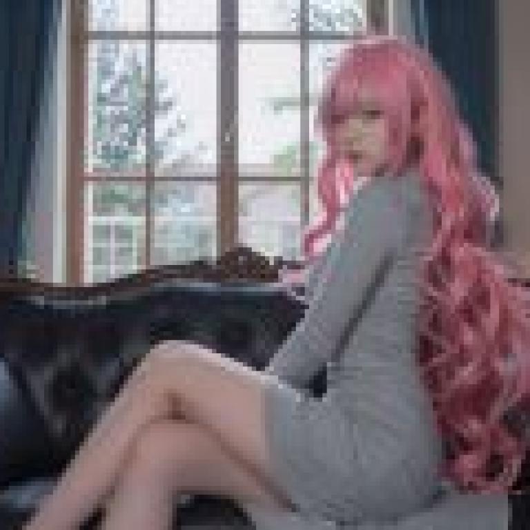 ZIT 翻譯：一個粉紅色頭髮的女孩坐在沙發扶手上。