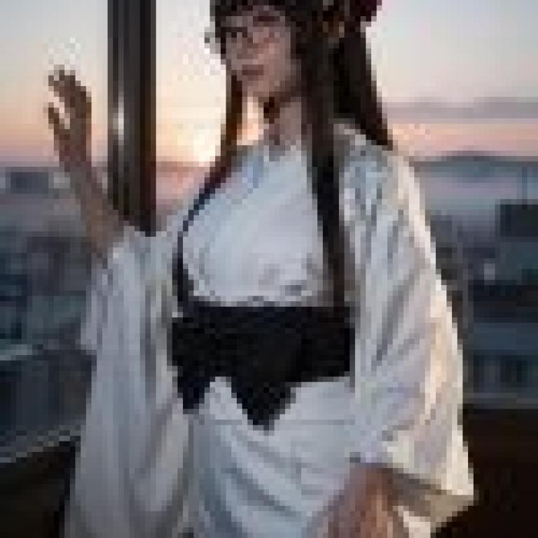 身穿和服、戴眼鏡的日本女子正望著窗外。