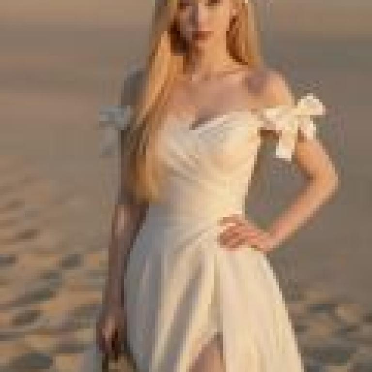 Phantom in the Desert，A young blonde woman wearing a white dress with ruffles on the shoulders.