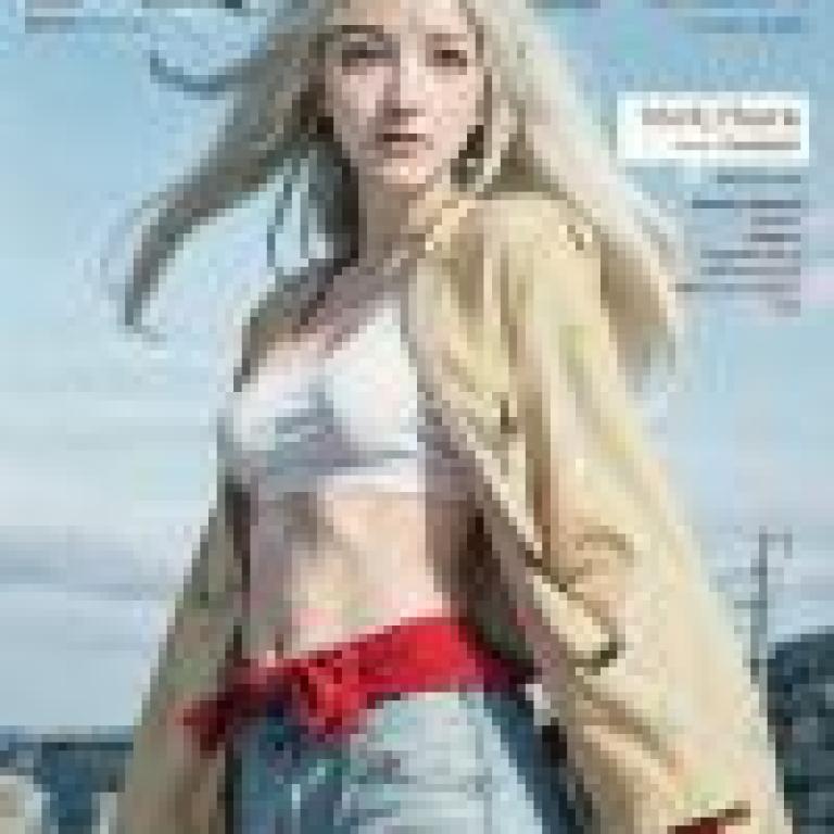 shion naruto，雜誌封面人物是一位身穿白襯衫和棕褐色外套的金髮女孩。