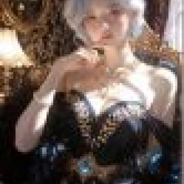 gorgeous，A blue haired woman in a black dress with blue accents sitting on a chair.