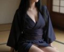 The Japanese Phantom of an Old House，Woman in blue kimono with glasses sitting on floor.