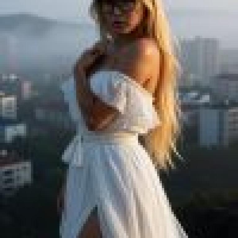 Dance of the Night，Woman in white dress in front of a city skyline.