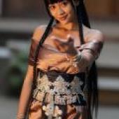 Exotic，A young Asian woman in a dress with many accessories is waving.