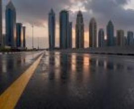 Roads leading to the city，City sky line with clouds and wet street.