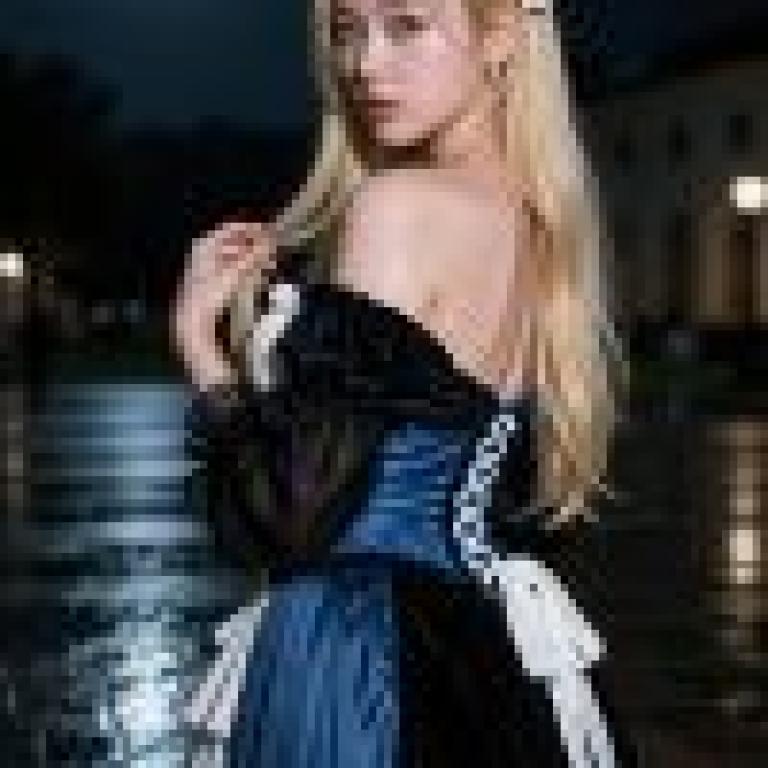 girls，A woman in a black and blue dress stands on a wet road with the moon in the sky.