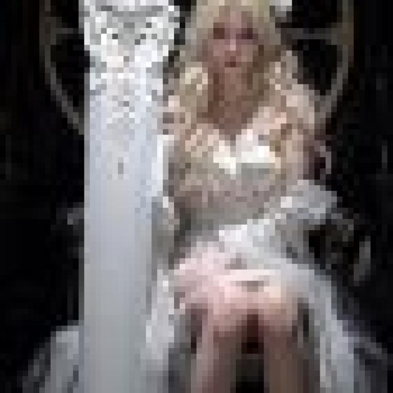 gorgeous，A woman in a white dress sits on a throne with her legs crossed.