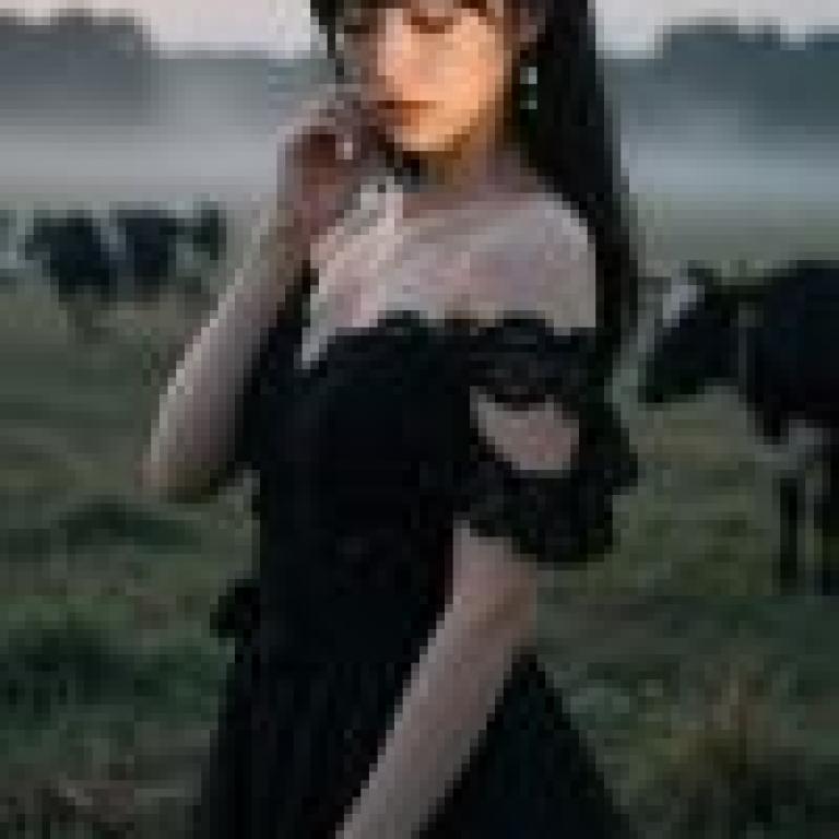 girls，A woman is standing in a grass field talking on the phone.