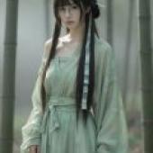 Beauty in the book，A woman with black hair and bangs stands in front of bamboo trees.