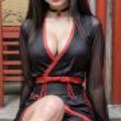 性感中國美女，一位身穿黑色洋裝的女子坐在木頭上。