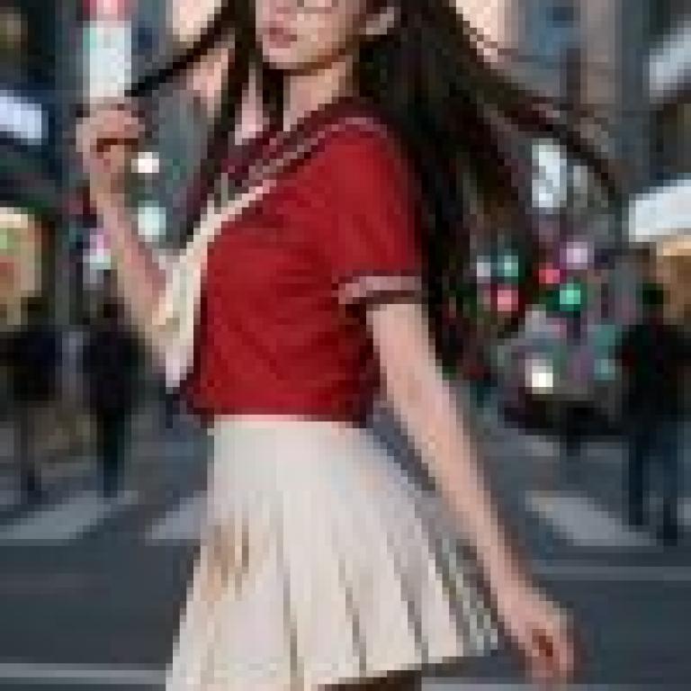 girls，A girl in glasses is wearing a school uniform and walking down the street.