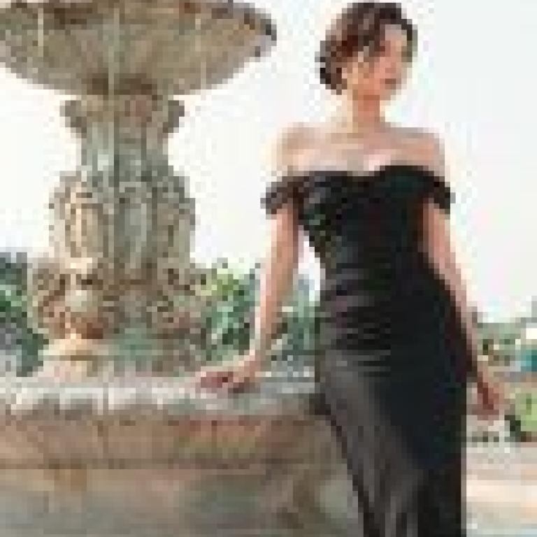 Memories by the pool，A woman standing beside a fountain in her black dress.