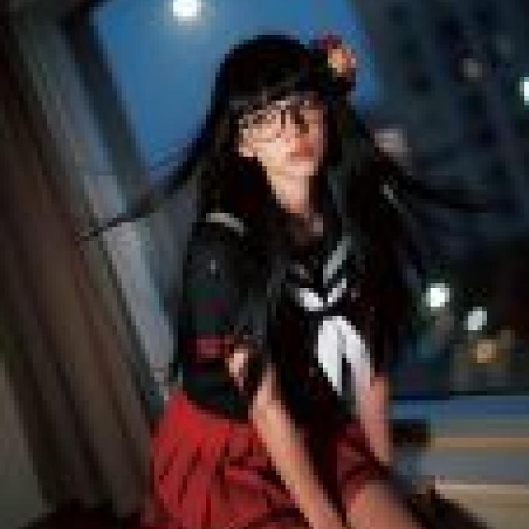 攝影師，一位戴眼鏡、穿著紅色洋裝的女士。