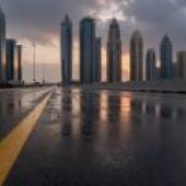 Roads leading to the city，City sky line with clouds and wet street.