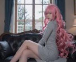 ZIT 翻譯：一個粉紅色頭髮的女孩坐在沙發扶手上。