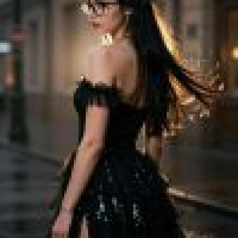 女孩們，一位身穿黑色洋裝、肩膀寬大、長髮的女子。