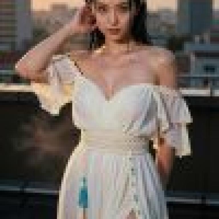一位身穿白色洋裝的女子站在屋頂上。