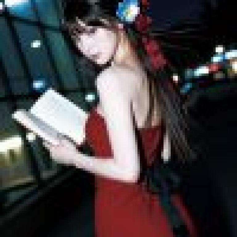 街頭攝影，一位穿著紅色洋裝的女子背對著鏡頭正在看書。