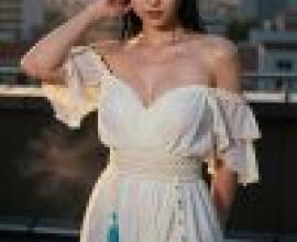 一位身穿白色洋裝的女子站在屋頂上。