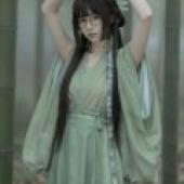 書中的美女，身穿綠色連身裙，長髮披肩，戴著眼鏡。