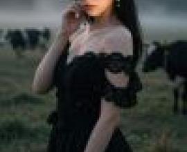 girls，A woman is standing in a grass field talking on the phone.