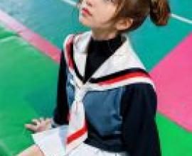 Nelvana of the series，Sakura Avalon，Girl with braids in school uniform sitting on floor.