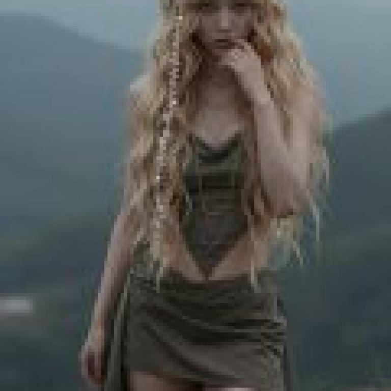 An unexpected encounter in the enchanted mountains，A young girl with long blonde hair wearing a brown dress standing in the middle of nowhere.