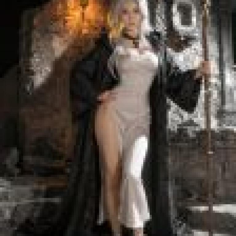 witch，A woman with long blonde hair wearing a white dress and a black cape.