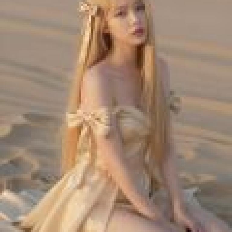 Phantom in the Desert，A young woman with long blonde hair sits on a beach.