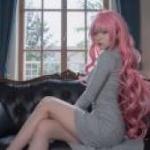 ZIT 翻譯：一個粉紅色頭髮的女孩坐在沙發扶手上。