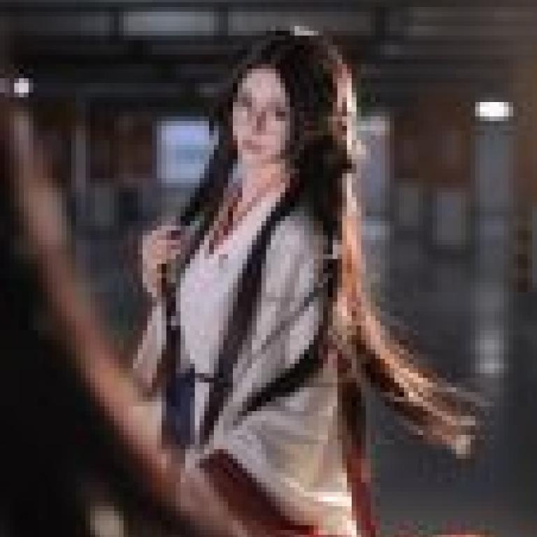 攝影師，一位戴著眼鏡、手持紅布的女子。