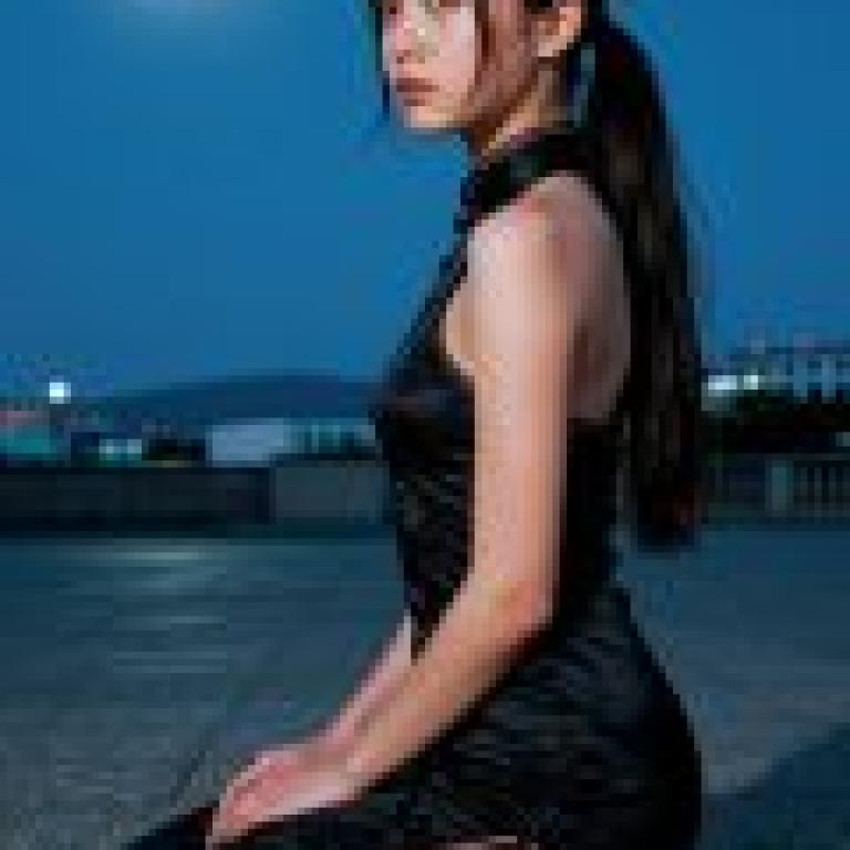 ZIT 01，A girl in black sitting on the ground at night.