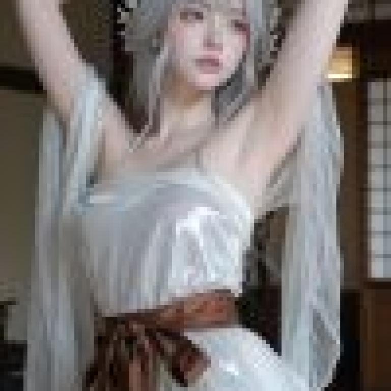 一位身穿白色洋裝、繫著領結的漂亮女士。