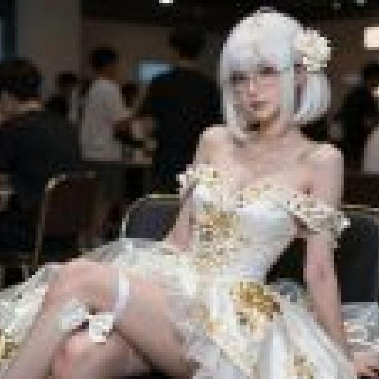 White flowers at the banquet，A model wearing glasses sits cross legged on a chair.