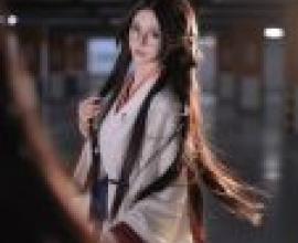 攝影師，一位戴著眼鏡、手持紅布的女子。