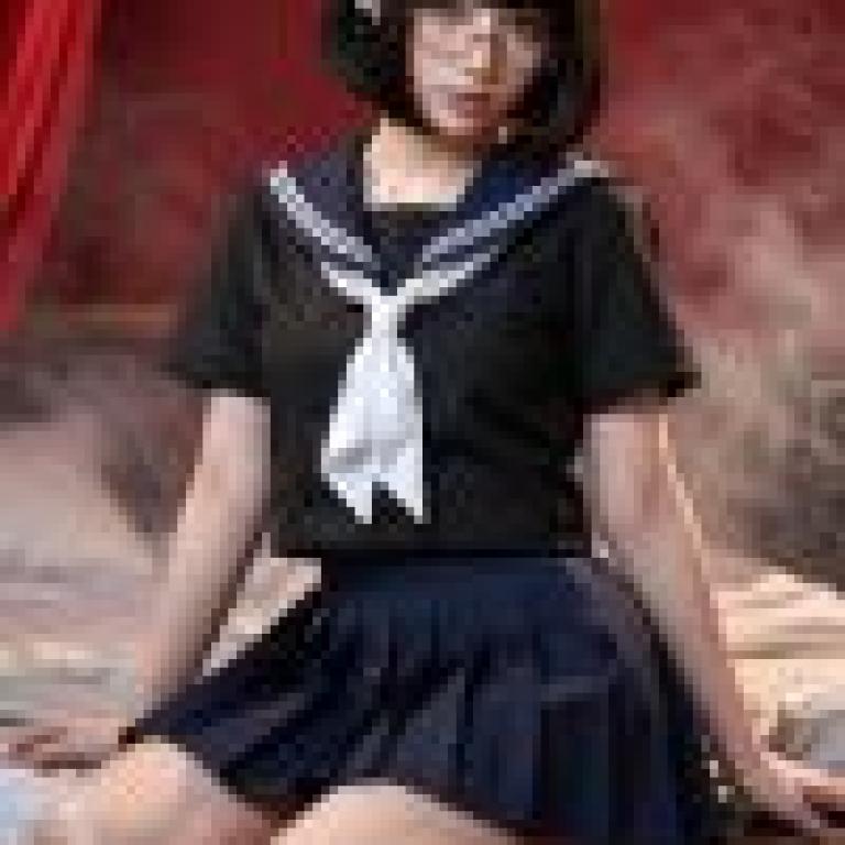 一個戴眼鏡的年輕女孩坐在床上。